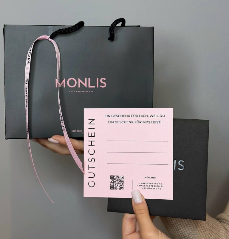MONLIS Gutscheinkarte und Geschenktüte in der Hand